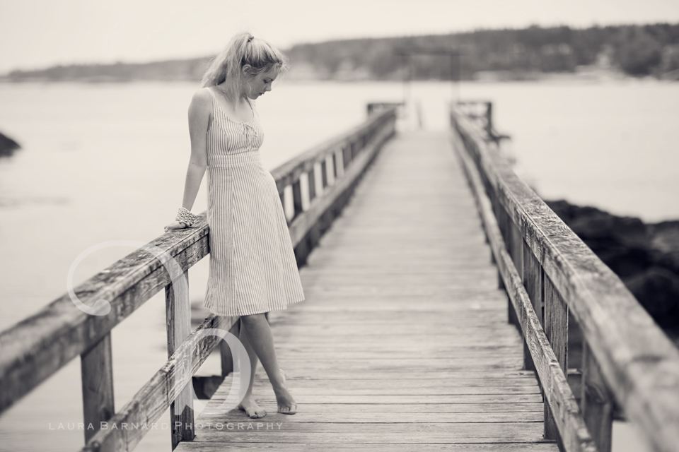A senior portrait walking a long dock, black and white.